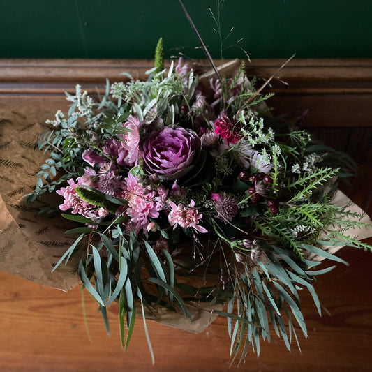 A hand tied bouquet of winter flowers by flower farm floristry