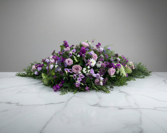 A customer specified request for all purple flowers for this coffin spray.