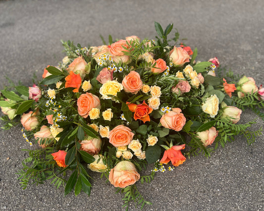 A customer specified they wanted a spray for a coffin made with roses in peach and orange colours.