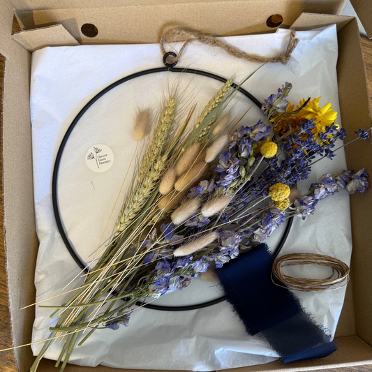 Dried flowers and a circular frame in a cardboard box.