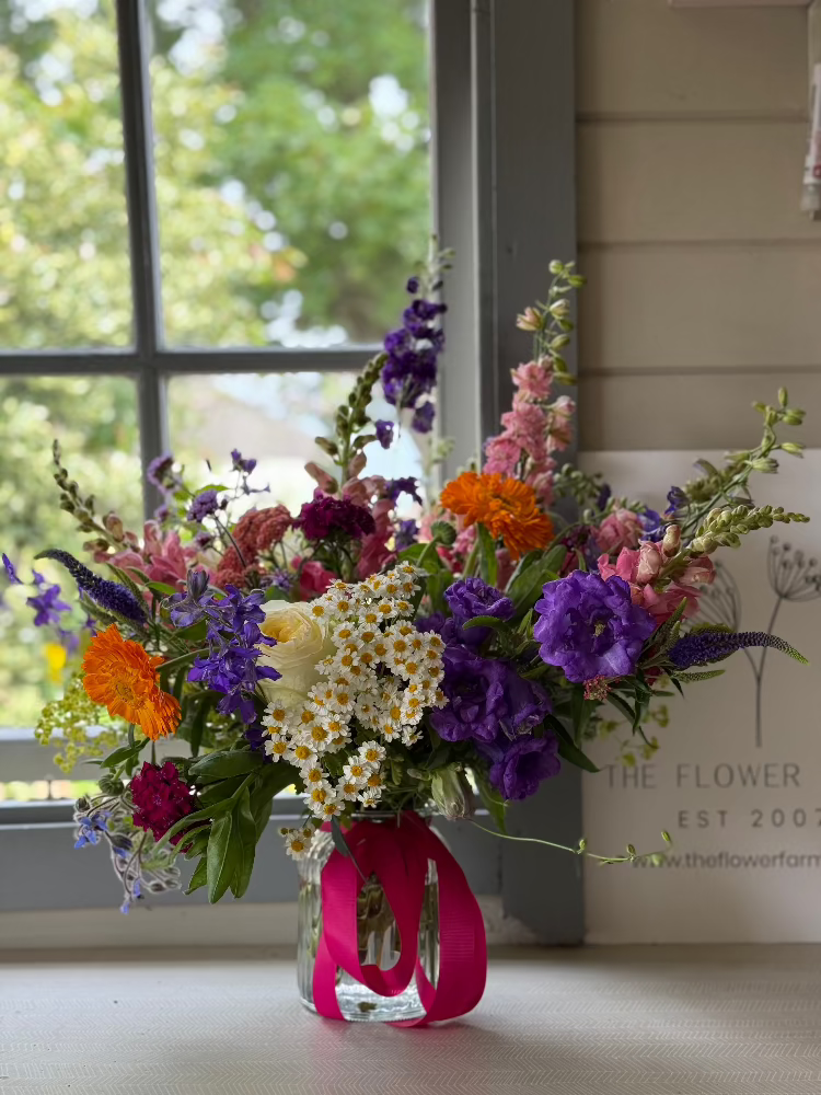 A stunning bouquet using homegrown flowers by Flower Farm Floristry, presented in a glass vase with a bow. Lancashire florist, Burscough, Ormskirk. PIcture by Millie Rose Content