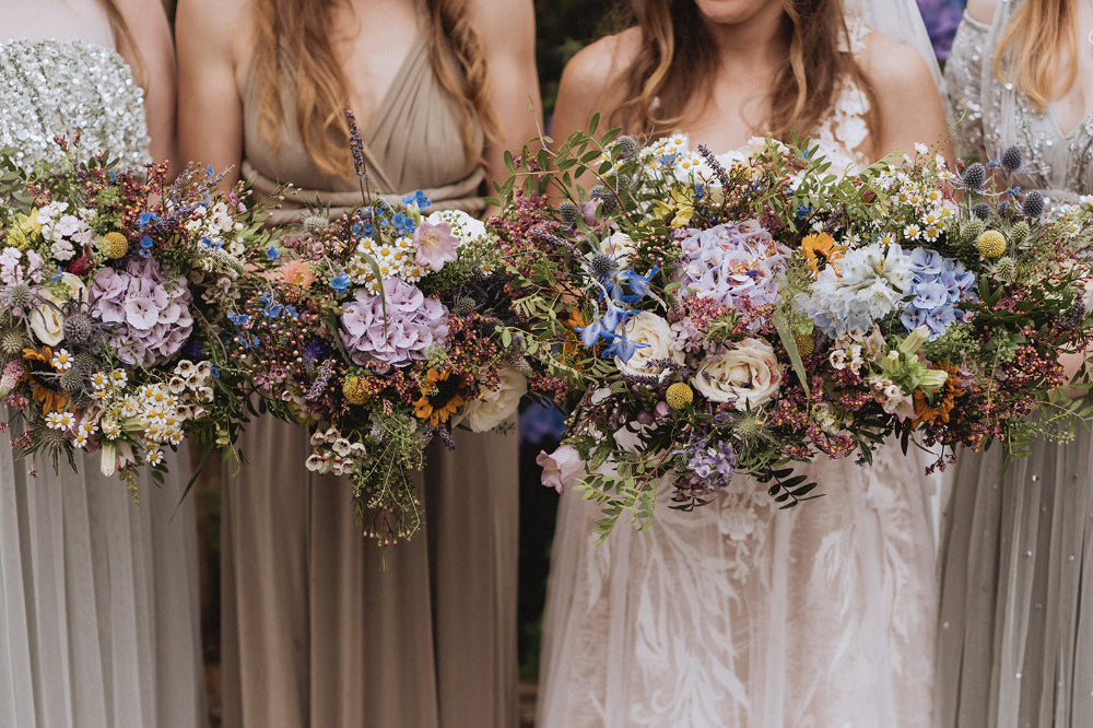 Mixed Summer florals including Sunflowers, Hydrangea, Tanacetum, Thistles, Craspedia and Roses.