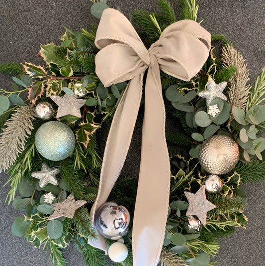 Decorative wreath with greenery, ornaments, and a luxury velvet ribbon.