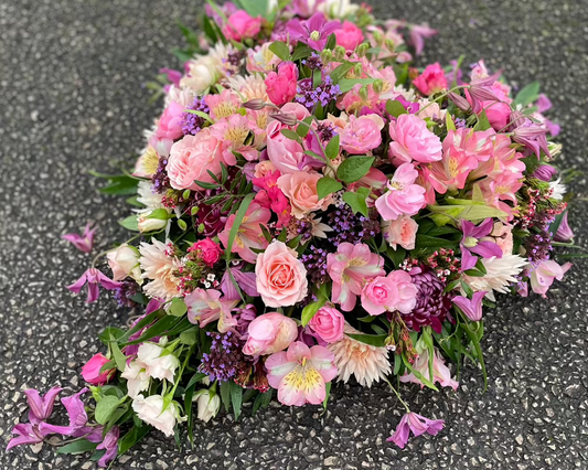 A heart of pink flowers created as a funeral tribute. Includes Roses, Clematis, Alstroemerias and Chrysanthemum.