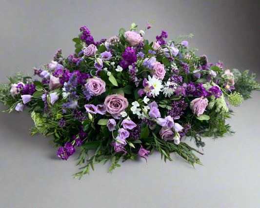 A customer specified request for all purple flowers for this coffin spray.