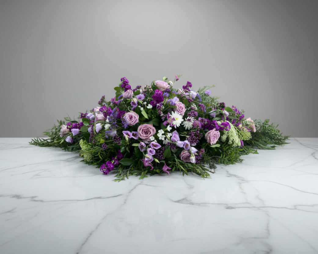 A customer specified request for all purple flowers for this coffin spray.