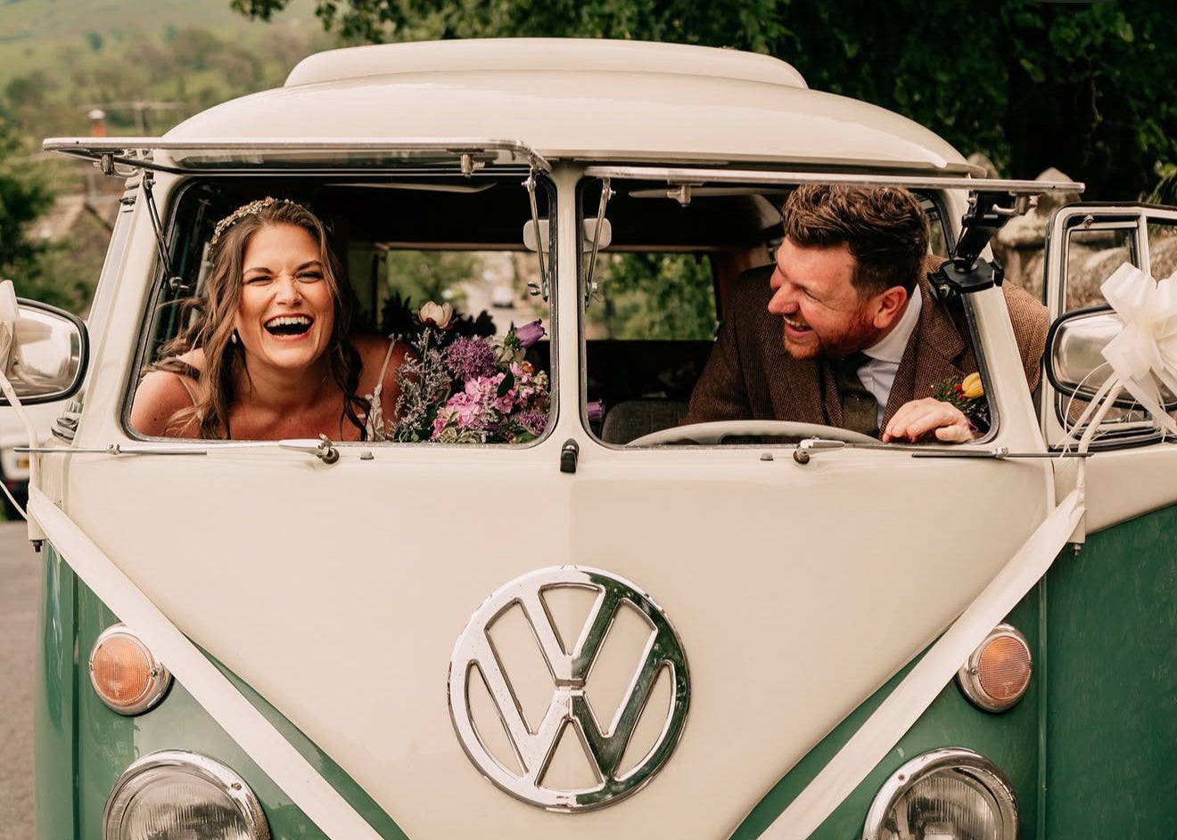 Couple sitting in a vintage Volkswagen van decorated for a wedding.