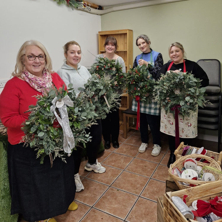 Five lovely women holding Christmas door wreaths at The Farm, Burscough