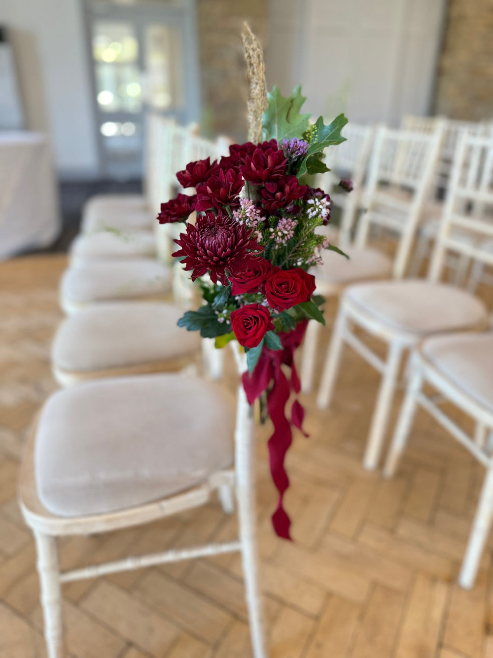 A bunch of flowers attached to a chair for a wedding.