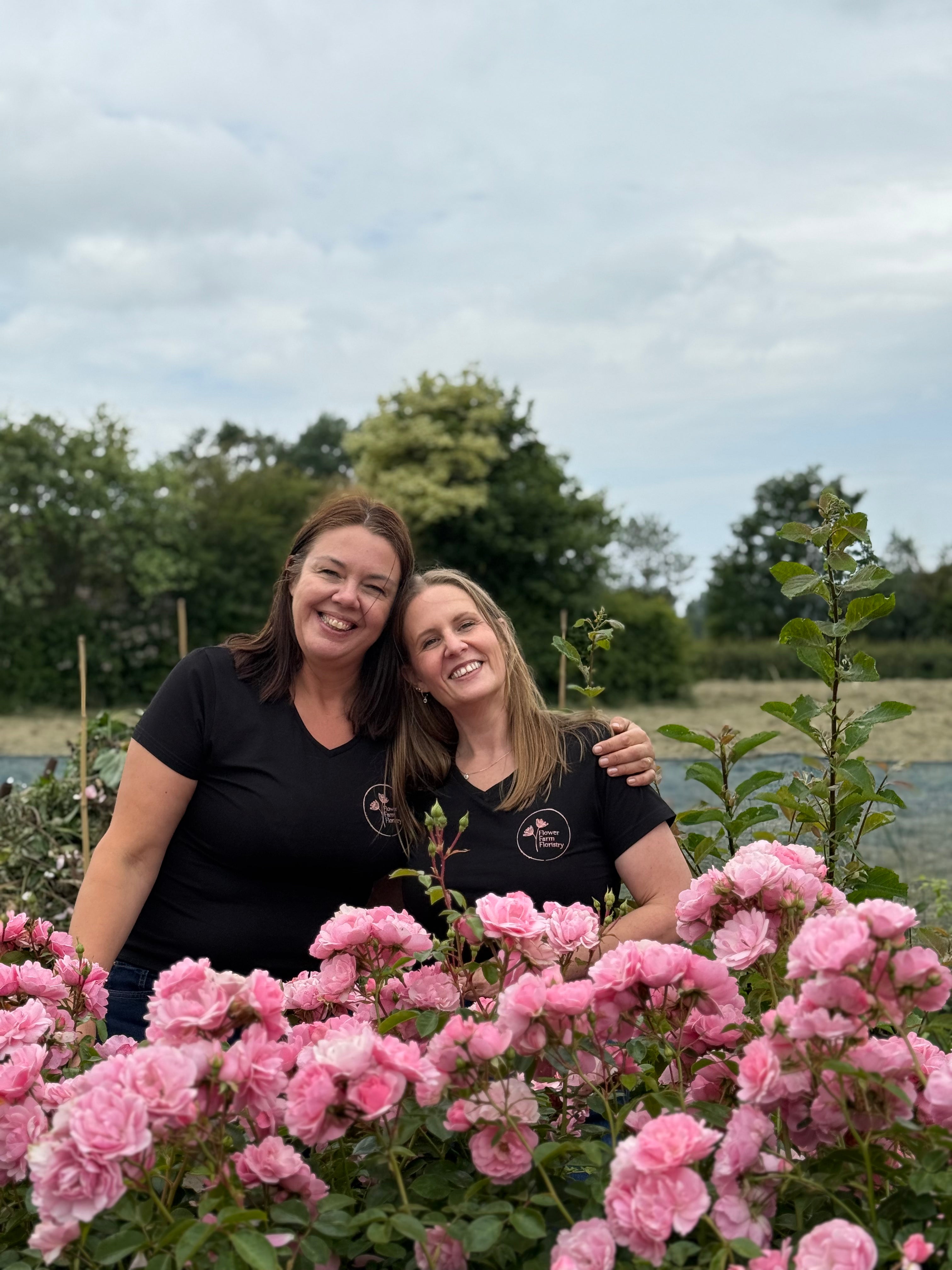 Clare and Alison behind the beautiful pin Roses in the flower field at Flower Farm Floristry - North West Wedding Florist, Burscough, Ormskirk, Lancashire. Picture by Millie Rose Content. Branded tshirts by Webby's Workwear, Mere Brow