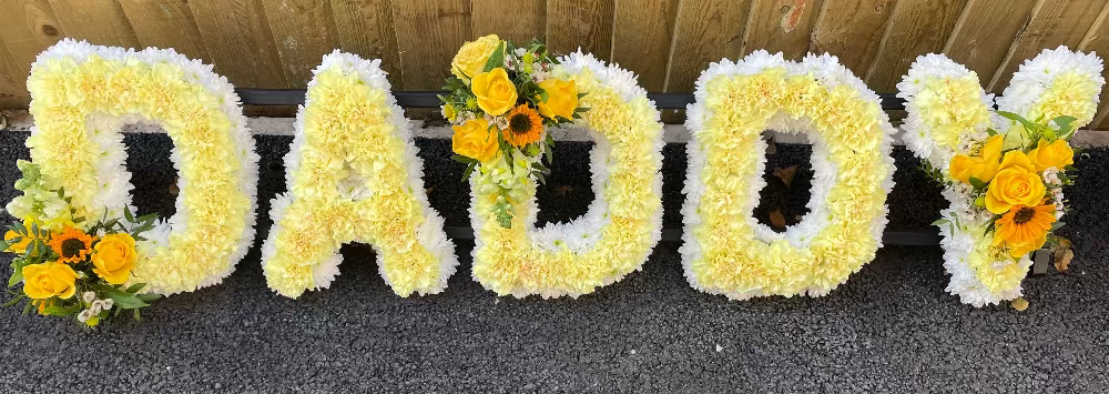 Floral arrangement spelling 'DADDY' with sunflowers