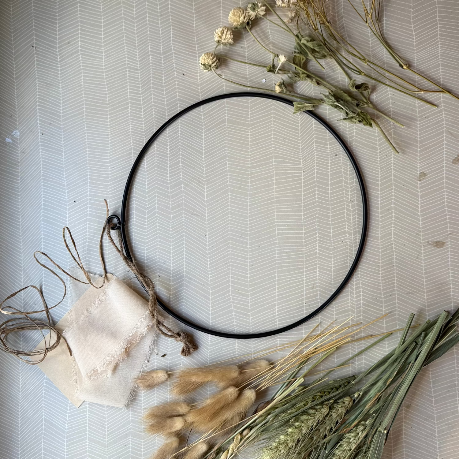 metal ring with dried flowers, ribbon, paper covered wire ready to make into a dried flower wreath.