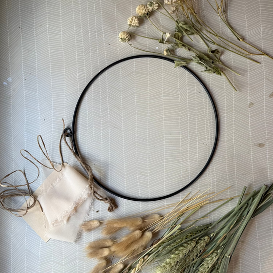 metal ring with dried flowers, ribbon, paper covered wire ready to make into a dried flower wreath.