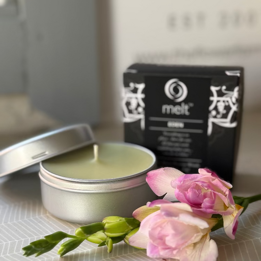 Open tin of a Eden scented candle with  'melt' packaging in the background.