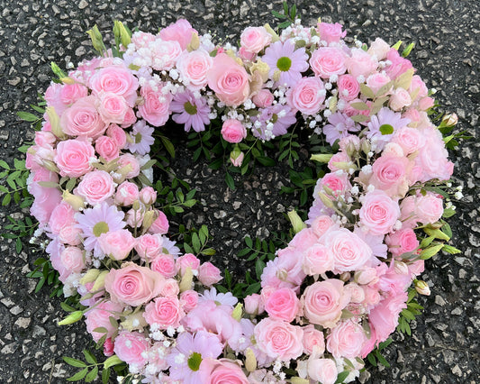 A pretty heart shaped arrangement of Roses, Lisianthus, Gypsophila and Lisianthus. Funeral tribute.