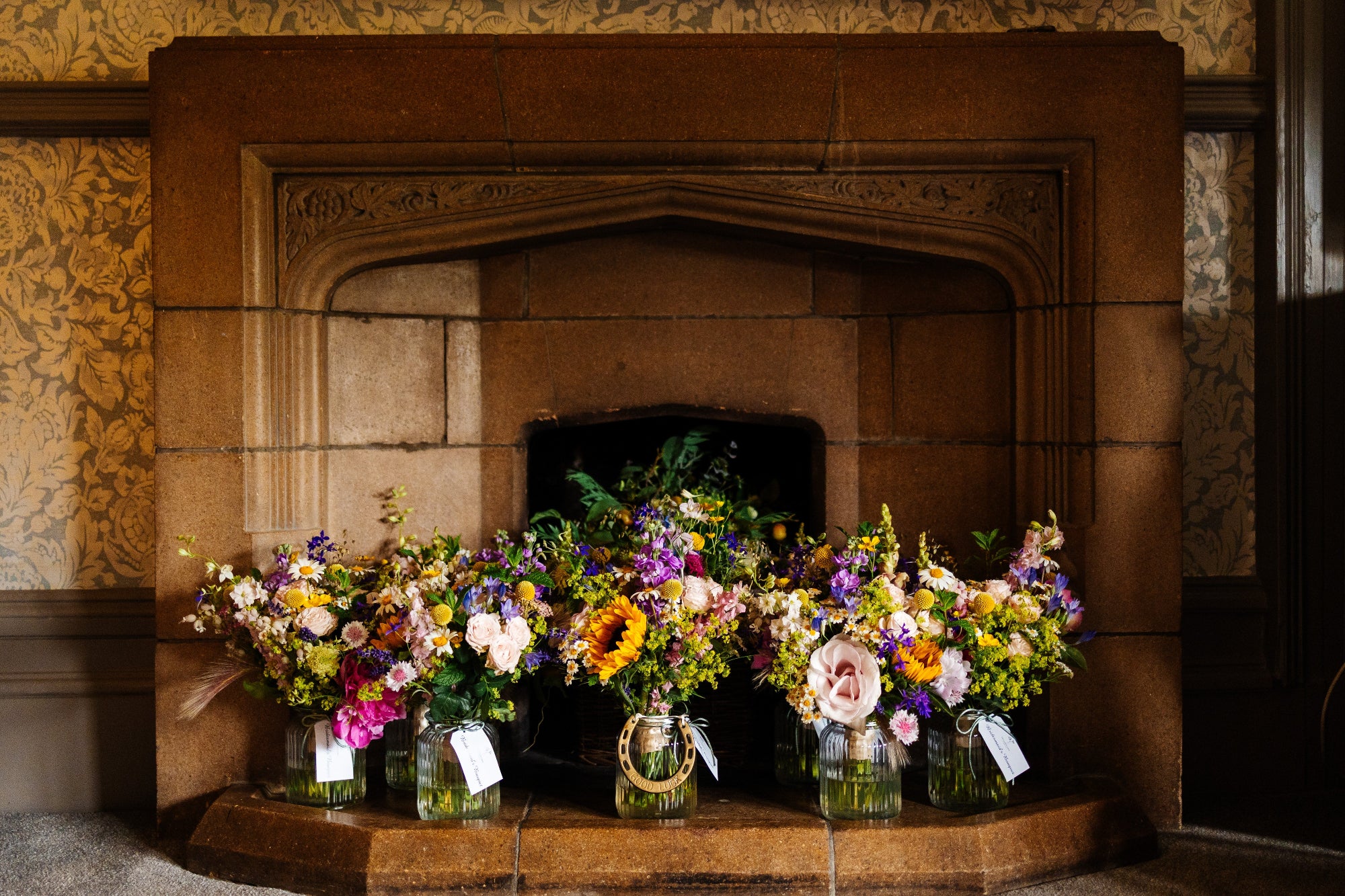 colourful Bride and bridesmaids bouquets in their delivery vases for a June wedding at Mitton Hall, photographer Fairclough Studios