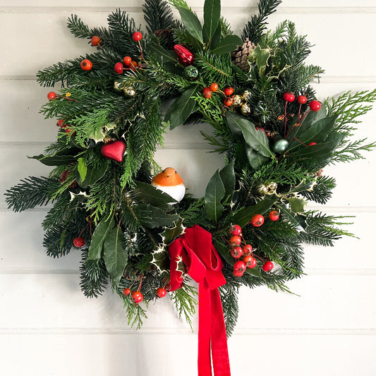 A fresh Christmas wreath with red berries and a red ribbon 