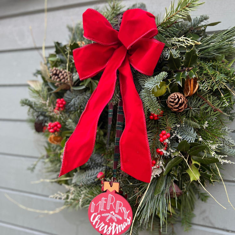 Christmas wreath with a red bow and 'Merry Christmas' tag.